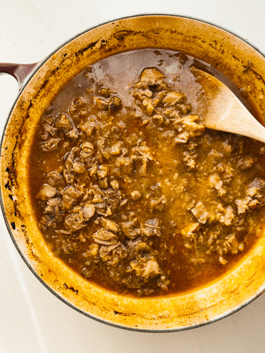 A top-down photo of shredded ossobuco meat, in a reduced sauce that forms a unctuous slow-cooked ragu. 