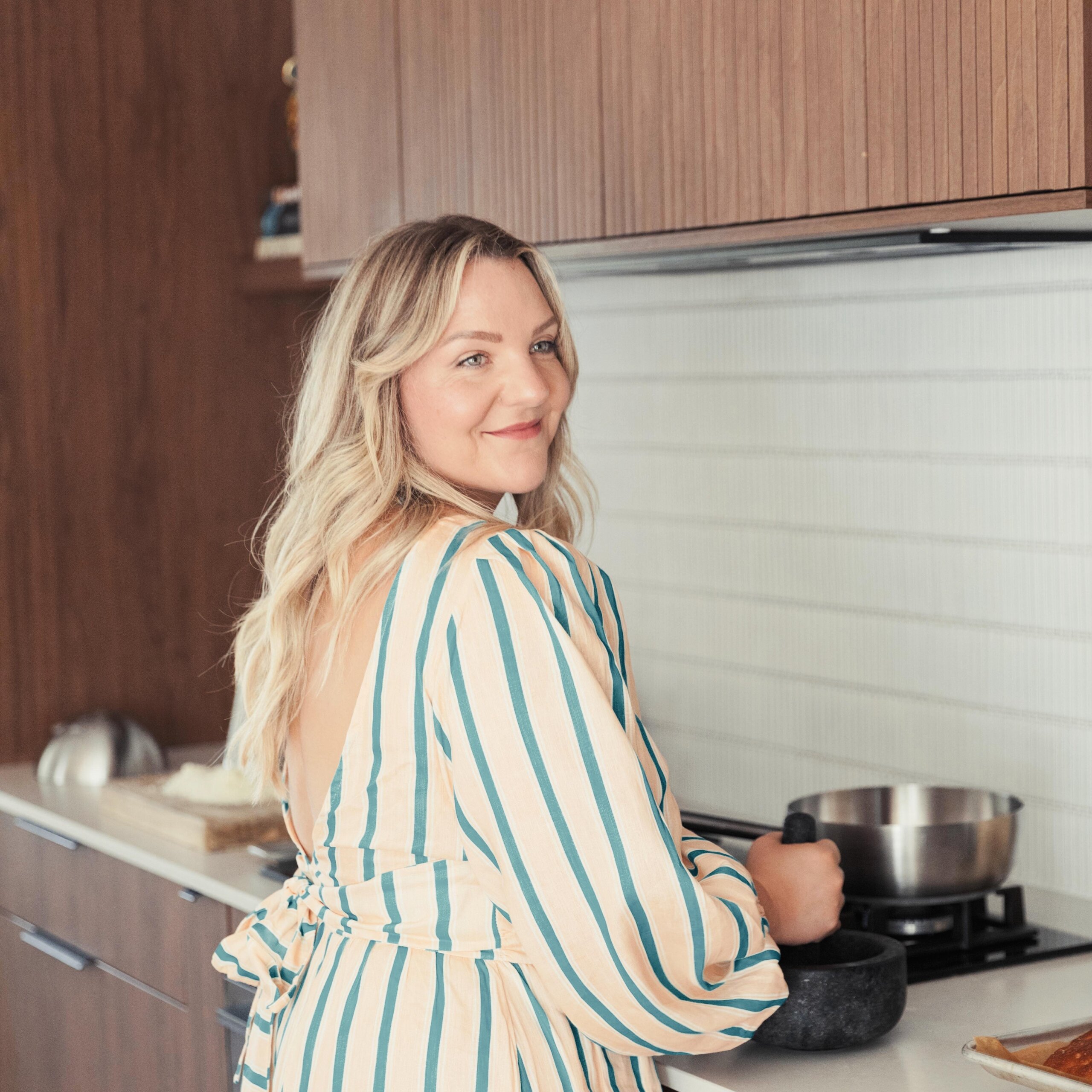 Gabriella Simonian photographed in her home kitchen, using a pestle and mortar.