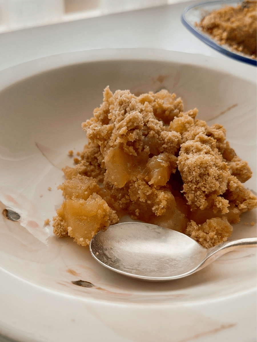Classic apple crumble served in a vintage bowl. With perfectly caramelised apple pieces and a crispy, golden crumble topping. 