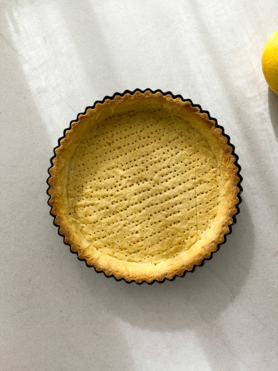 A top down photo of a blind baked pate sucree pastry shell.