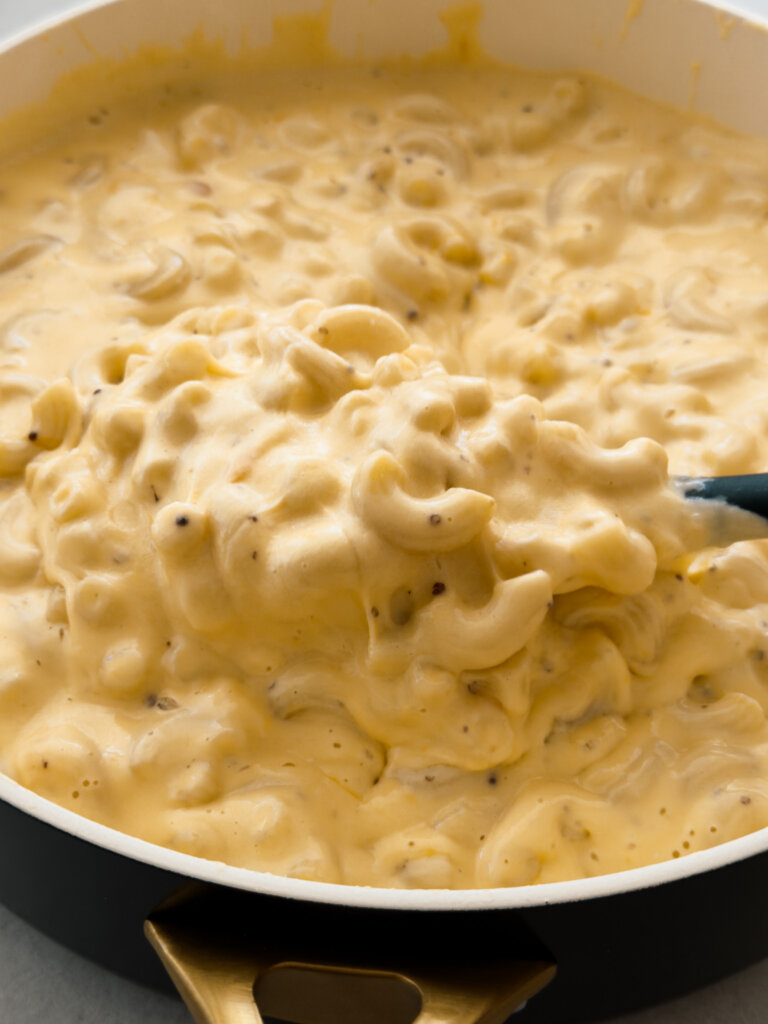 A close up photo of a pot of creamy elbow macaroni and cheese.
