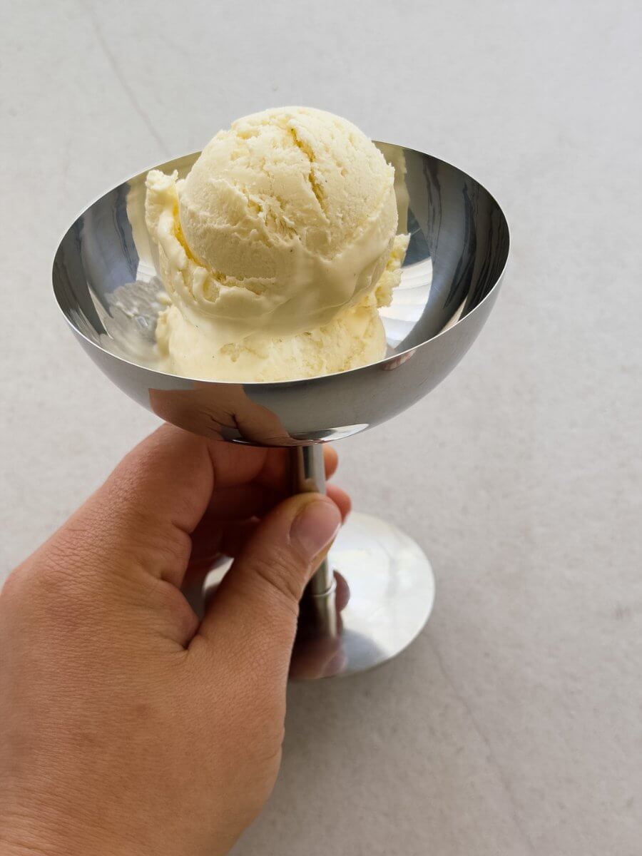Two scoops of creamy salted vanilla and tahini ice cream, served in a metal coupe. 