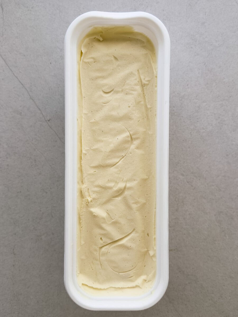 A top down photo of a tub of salted vanilla and tahini ice cream. 