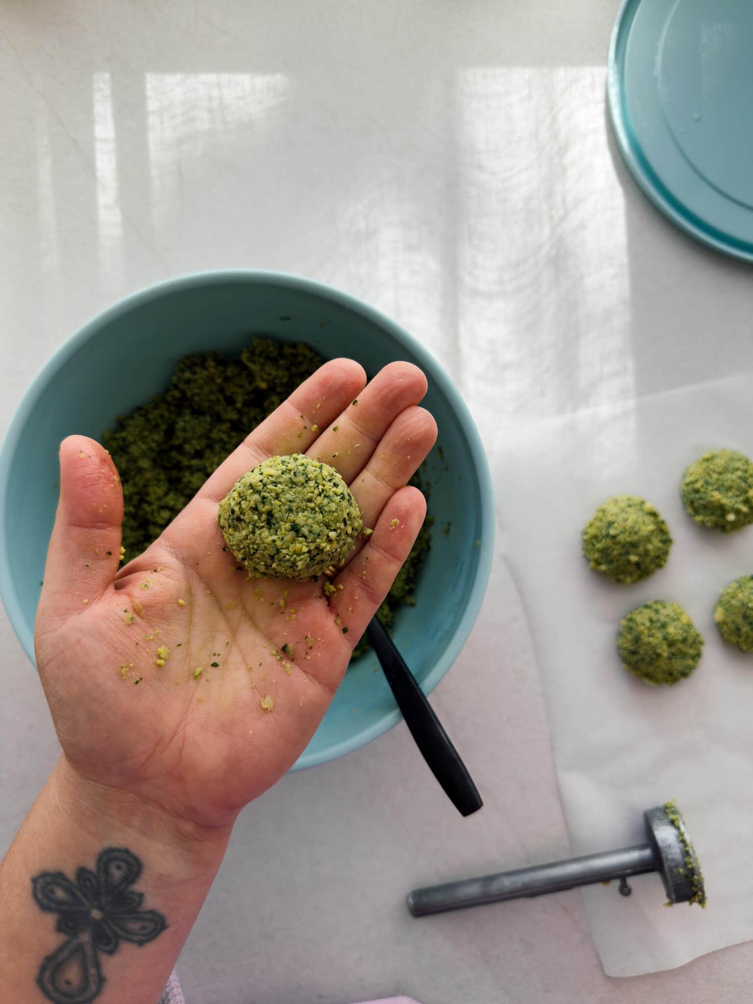 A hand-formed falafel is shown being held in the palm of a hand. 